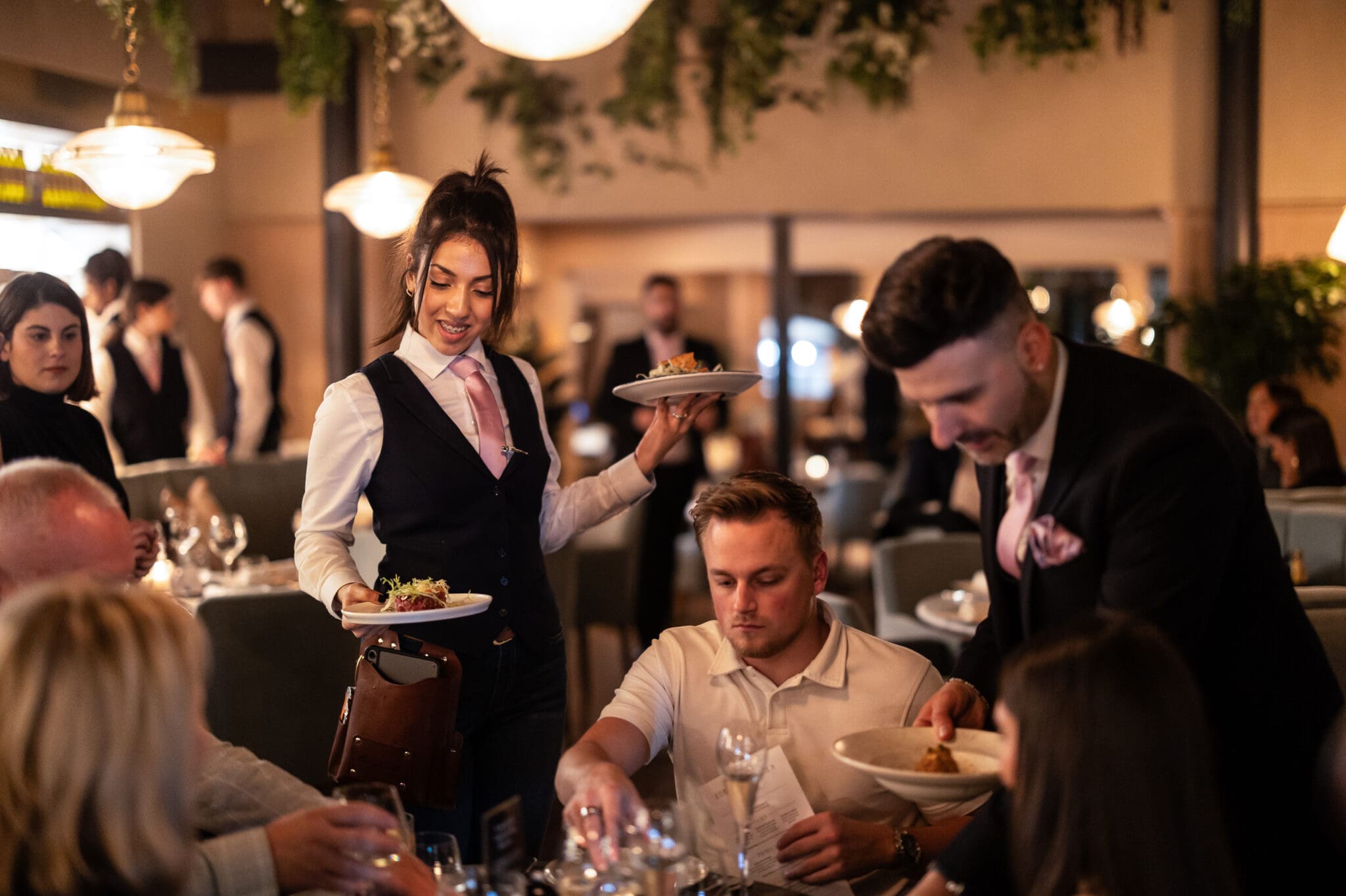 Waiters are serving food to a small group of people